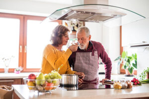 Senior couple preparing food in the kitchen. An old man and woman inside the house.